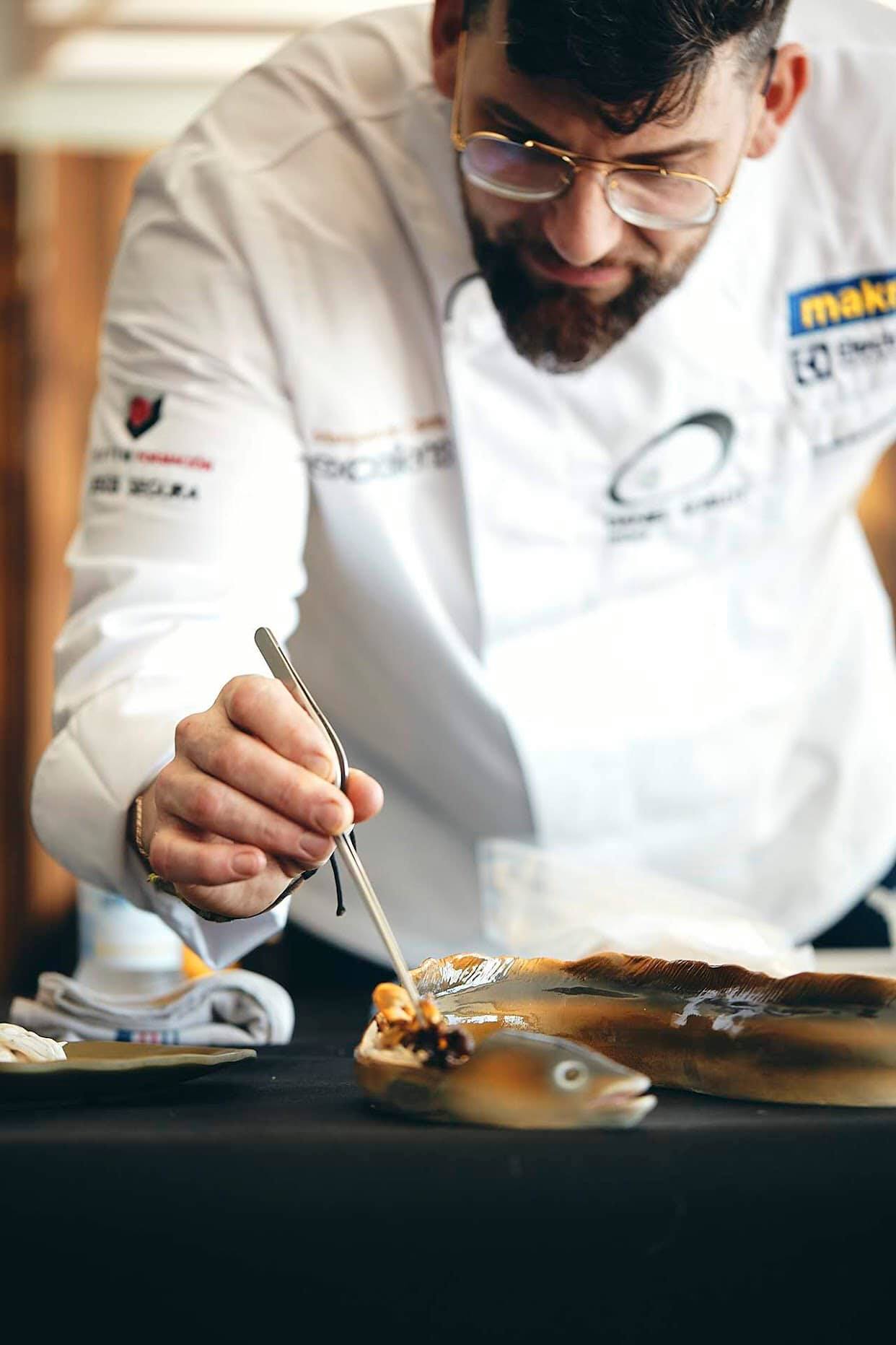 Curso de cocina profesional con chef realizando técnica de precisión